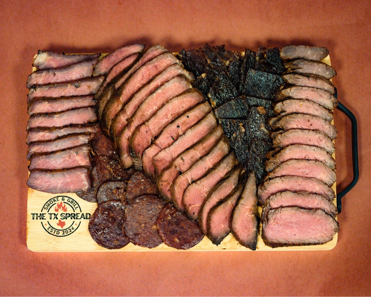 A customized Tx Spread board arranged for an order, with sliced smoked meats and salami rounds