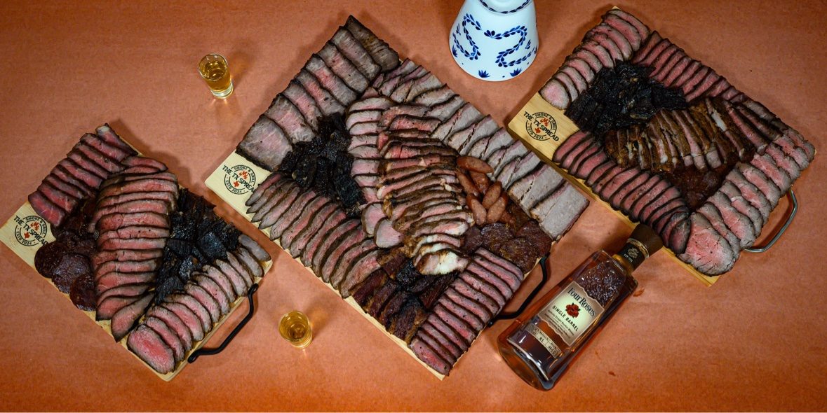 Three Tx Spread boards laid out together with a bottle of bourbon and tasting glasses