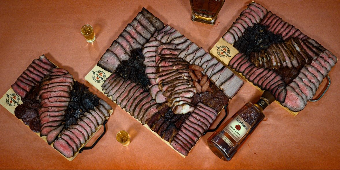 Three Tx Spread boards photographed from above with a bottle of bourbon